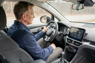 Conducteur consultant la consommation de carburant sur le tableau de bord numérique d'un SUV compact SEAT ATK