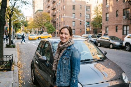 Femme souriante en ville avec voiture compacte