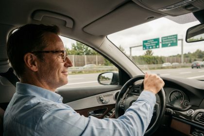 Homme en voiture sur autoroute européenne en conduite détendue