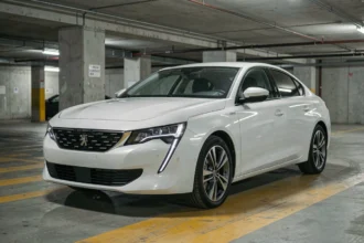 Peugeot 508 1.6 PureTech 225 vue de trois quarts avant dans un parking urbain, illustrant la fiabilité moteur avant achat