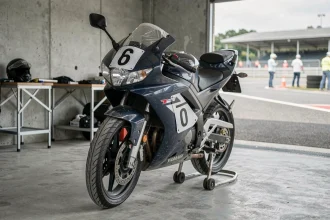 Yamaha TZR 125 préparée pour la piste avec cache-phares et panneaux de numéro dans un garage de paddock